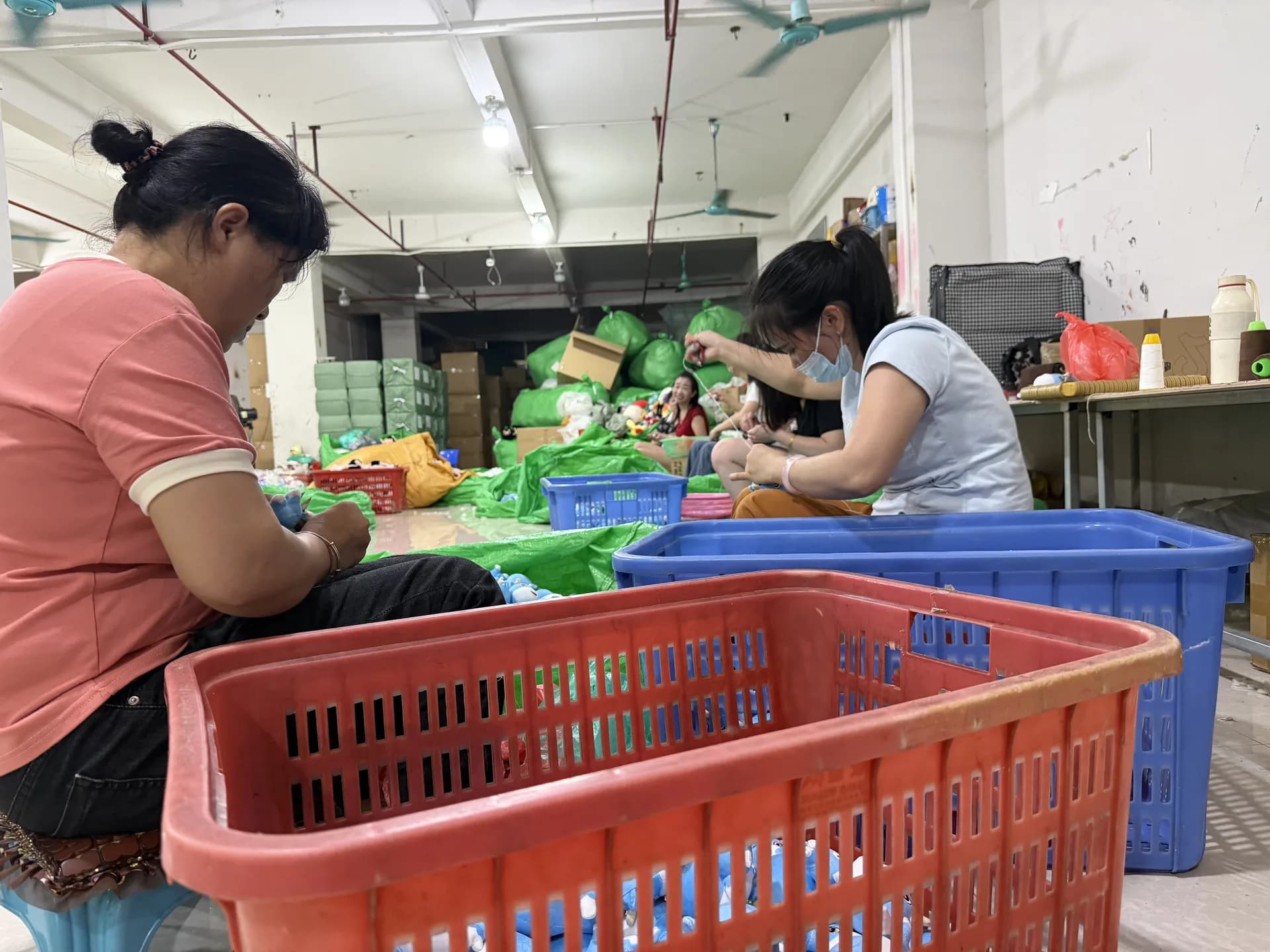 Workshop team hand-finishing custom plush toys during a production run